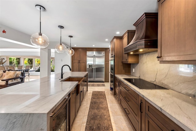 kitchen with custom exhaust hood, appliances with stainless steel finishes, pendant lighting, and light stone counters