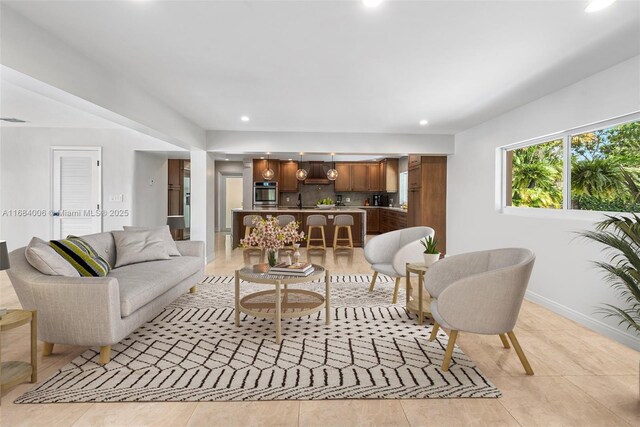 kitchen featuring light stone counters, appliances with stainless steel finishes, custom exhaust hood, and hanging light fixtures