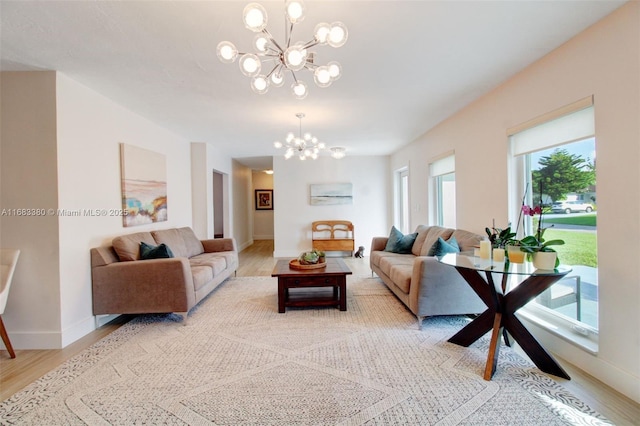 living room featuring a notable chandelier and light hardwood / wood-style flooring