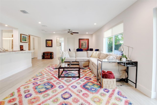 living room featuring ceiling fan and light wood-type flooring