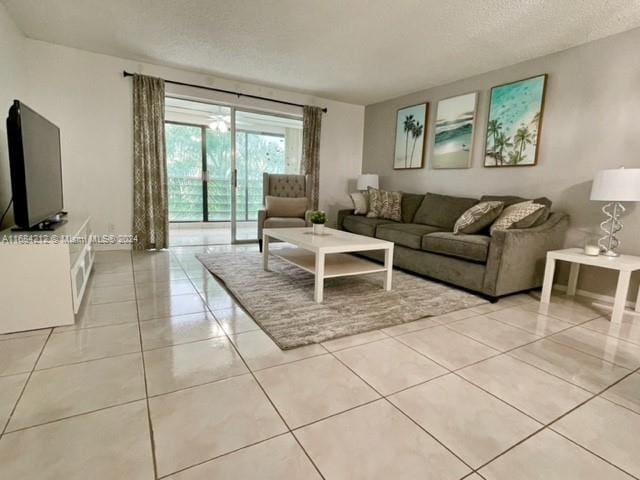 tiled living room featuring a textured ceiling