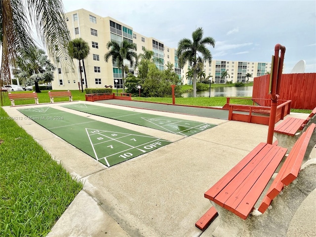 surrounding community with a lawn and a water view