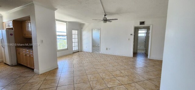 unfurnished room featuring ceiling fan and ornamental molding