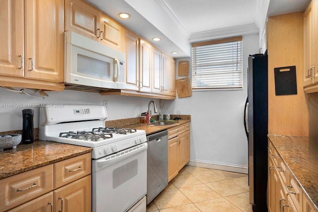 kitchen with crown molding, light tile patterned floors, a sink, stainless steel appliances, and baseboards