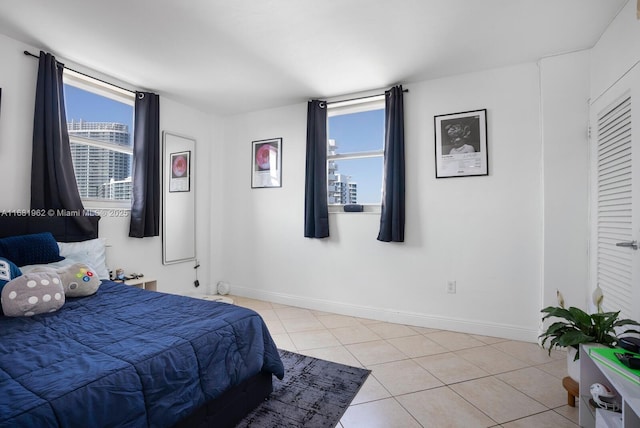 bedroom featuring light tile patterned floors and baseboards