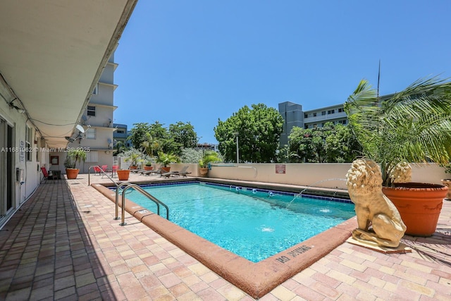 pool with a patio area and fence