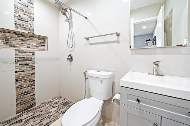 bathroom featuring tasteful backsplash, tiled shower, vanity, and toilet