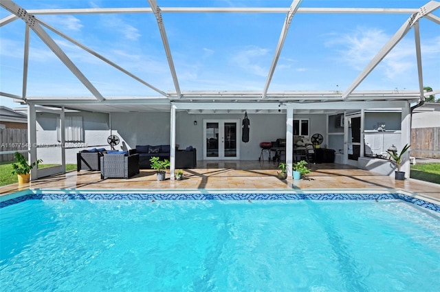 view of pool with french doors, an outdoor hangout area, glass enclosure, and a patio