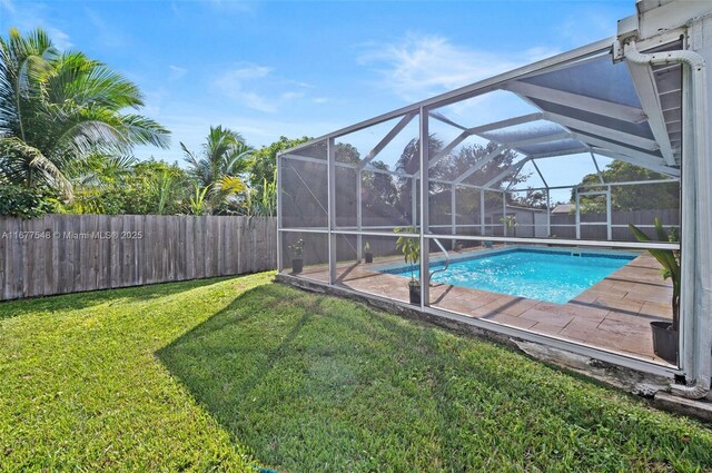 view of pool featuring a lawn and glass enclosure