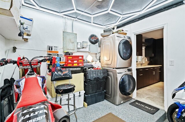 washroom with stacked washer and dryer, sink, and electric panel