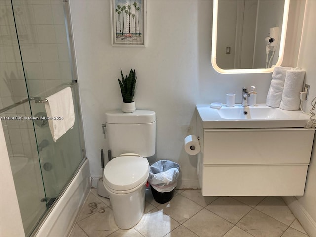 full bathroom with toilet, enclosed tub / shower combo, vanity, and tile patterned flooring