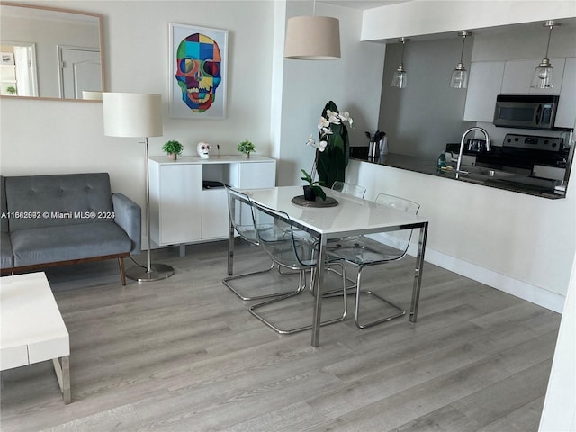 dining room featuring sink and light wood-type flooring