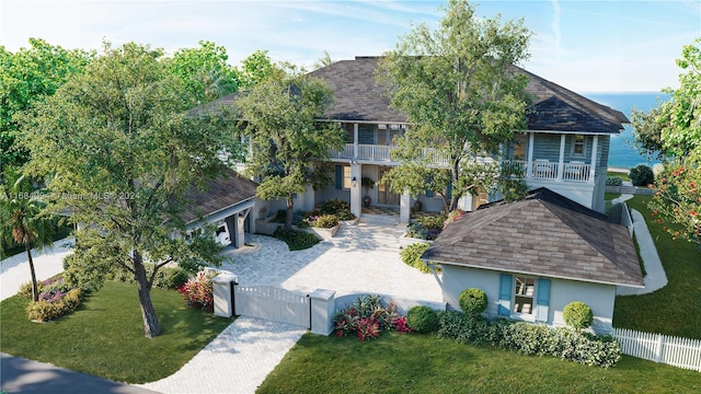 view of front of home featuring a water view, covered porch, a balcony, and a front lawn