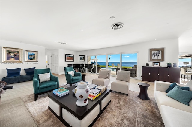 living room featuring a water view and light wood-type flooring