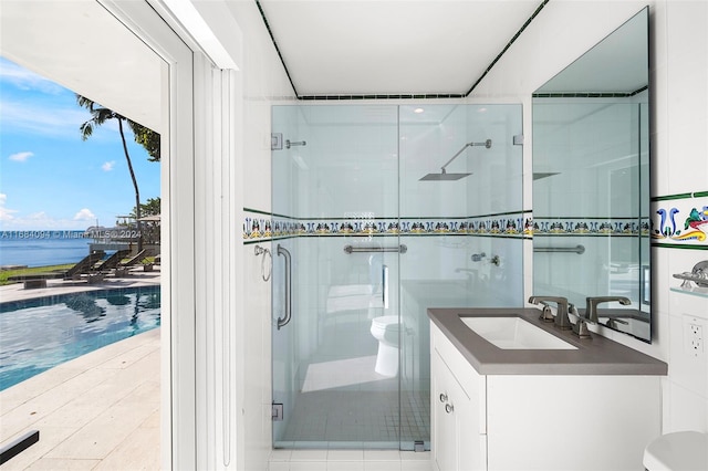 bathroom with vanity, toilet, a water view, and a shower with door