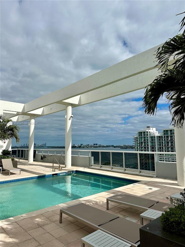 view of pool with a patio area and a water view