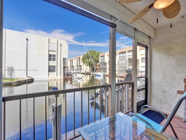 balcony featuring a water view and ceiling fan