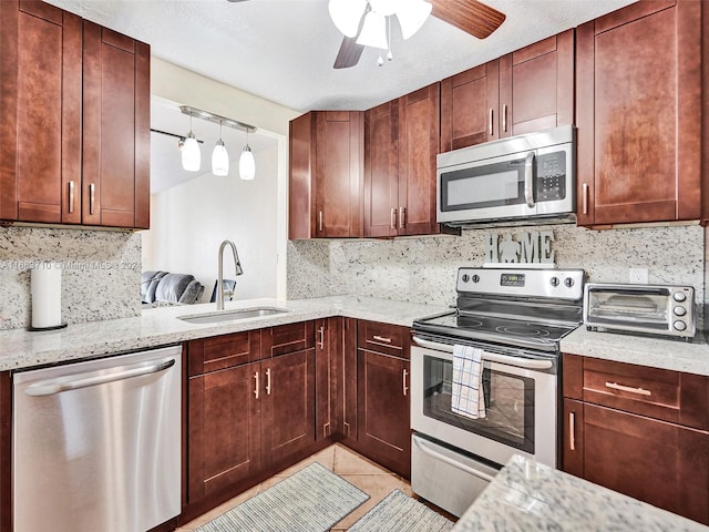 kitchen featuring light stone countertops, sink, appliances with stainless steel finishes, and light tile patterned floors