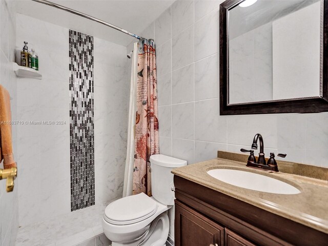 bathroom featuring vanity, tile walls, a shower with curtain, and toilet