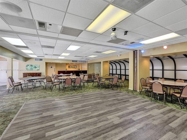 dining space featuring hardwood / wood-style floors and a paneled ceiling