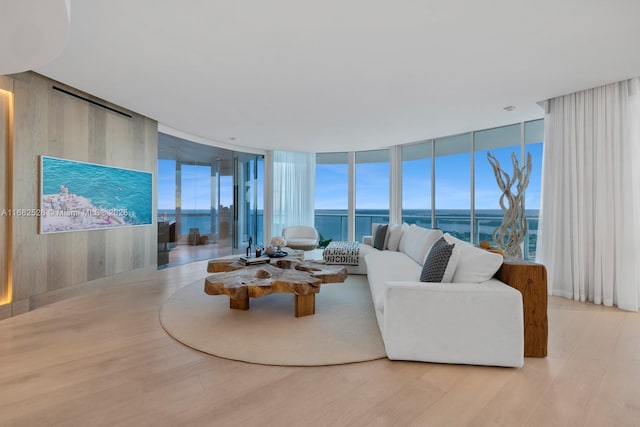 living room featuring expansive windows, wooden walls, and wood finished floors