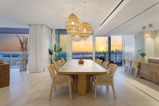 dining space with light hardwood / wood-style flooring, expansive windows, and a healthy amount of sunlight