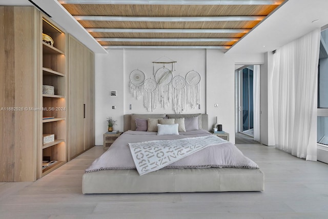 bedroom featuring beam ceiling, wood ceiling, and light hardwood / wood-style flooring