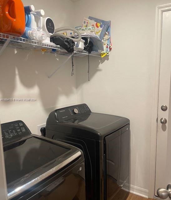 laundry area featuring wood-type flooring and washing machine and clothes dryer