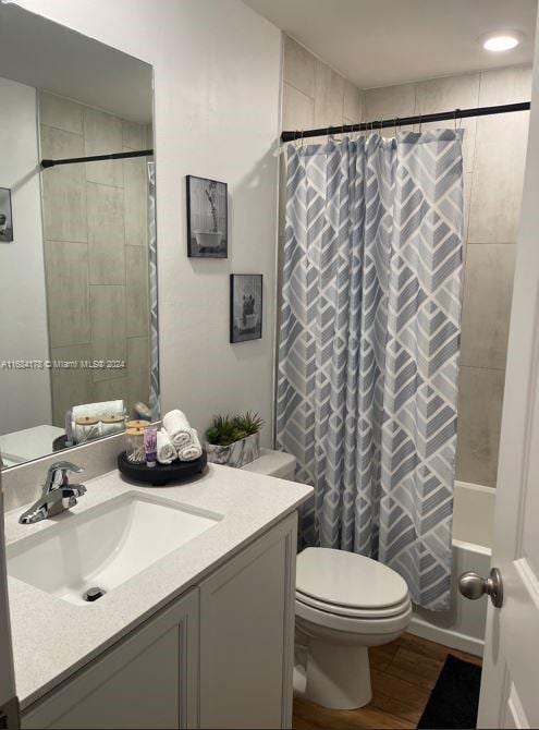 bathroom with vanity, toilet, hardwood / wood-style flooring, and walk in shower