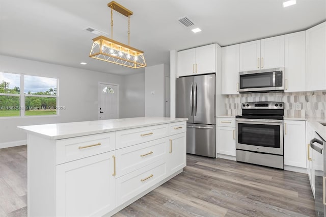 kitchen featuring white cabinetry, pendant lighting, appliances with stainless steel finishes, and tasteful backsplash