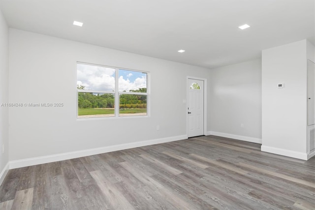 unfurnished room with visible vents, baseboards, and wood finished floors