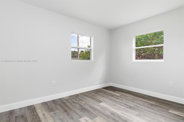 spare room featuring hardwood / wood-style floors and a healthy amount of sunlight