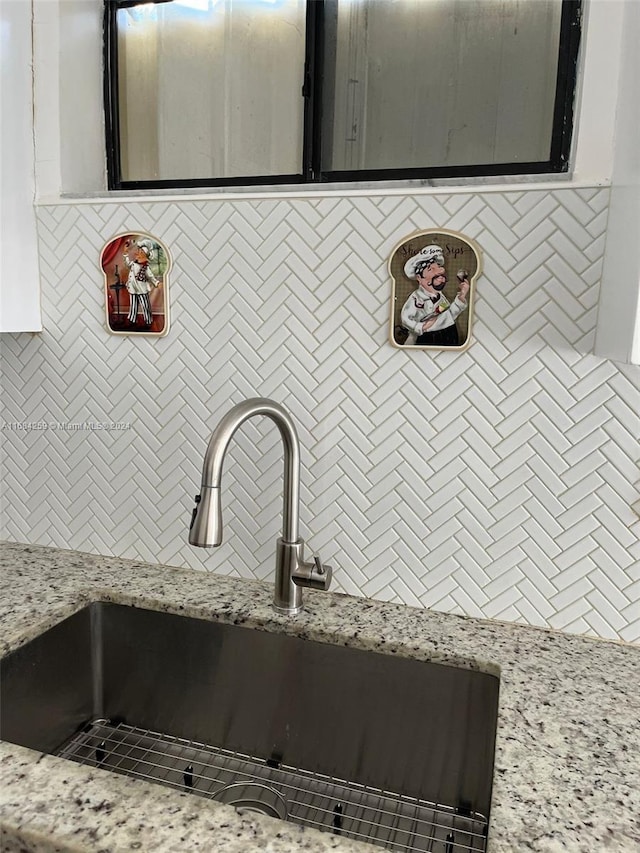 details featuring light stone countertops and sink