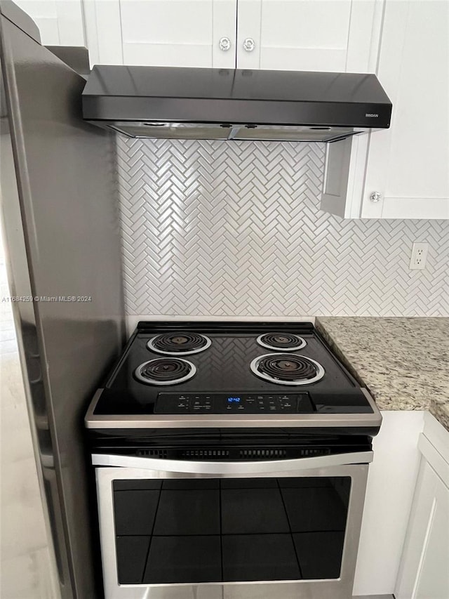 kitchen with stainless steel electric stove, white cabinetry, light stone countertops, and range hood