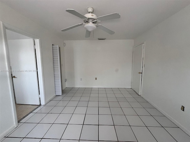 empty room with ceiling fan and light tile patterned flooring