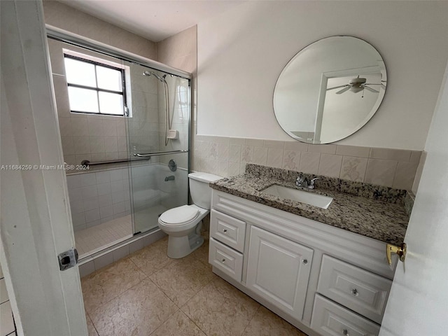 bathroom with ceiling fan, vanity, an enclosed shower, and toilet