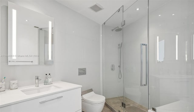 bathroom with vanity, toilet, and a shower with shower door