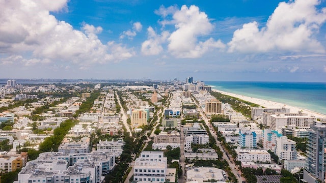 drone / aerial view with a water view and a beach view