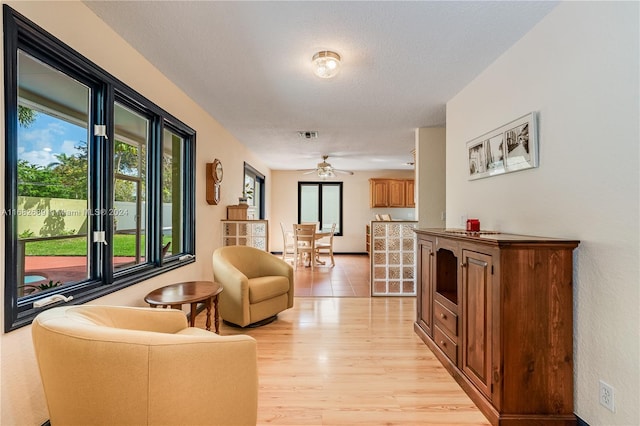 hall with light hardwood / wood-style floors and a textured ceiling