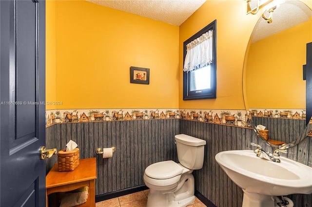 bathroom featuring sink, a textured ceiling, toilet, and tile patterned flooring