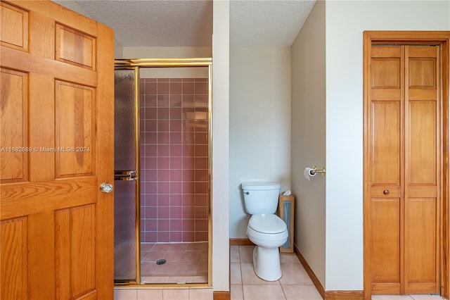 bathroom featuring toilet, tile patterned floors, walk in shower, and a textured ceiling