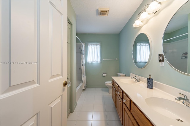 full bathroom with shower / tub combo, a textured ceiling, toilet, vanity, and tile patterned floors