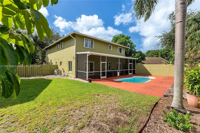 back of house with a fenced in pool, a patio area, a yard, and a sunroom