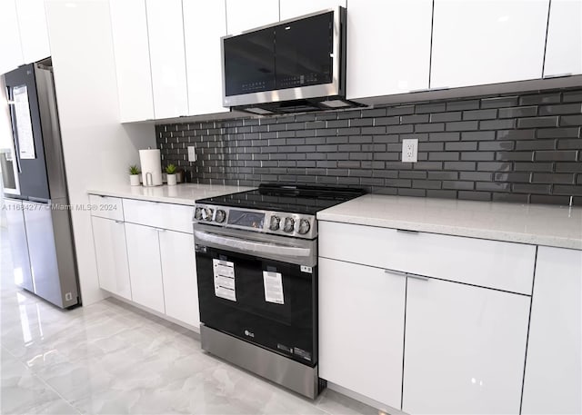 kitchen with appliances with stainless steel finishes, decorative backsplash, and white cabinets