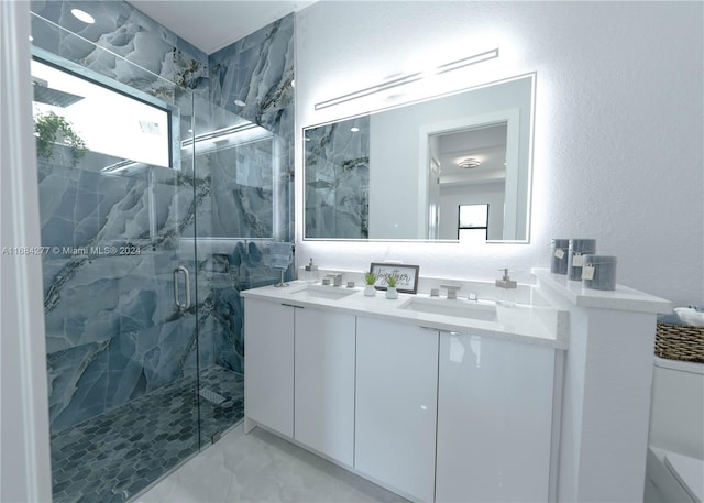 bathroom featuring vanity, a shower with shower door, and plenty of natural light