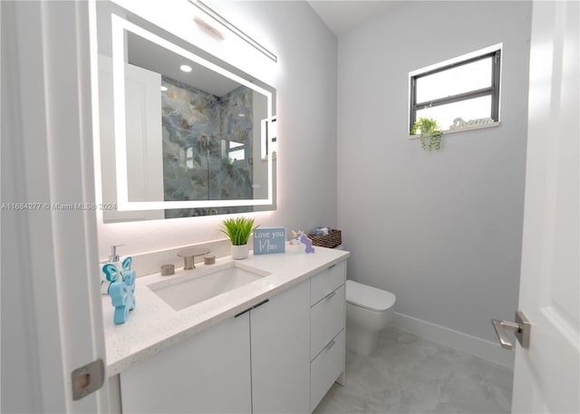 bathroom featuring vanity, toilet, and tiled shower