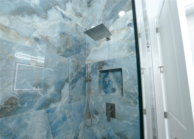 interior details featuring a tile shower