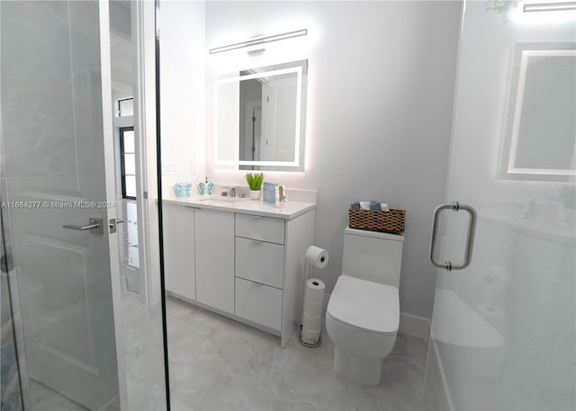 bathroom featuring vanity, toilet, and a shower with door