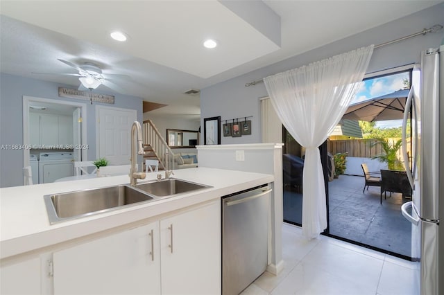 kitchen with white cabinetry, washer and dryer, stainless steel appliances, and sink