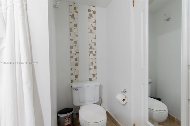 bathroom featuring toilet, tile patterned floors, and a shower with shower curtain